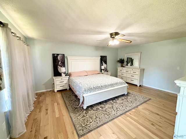 bedroom featuring ceiling fan, light hardwood / wood-style floors, and a textured ceiling