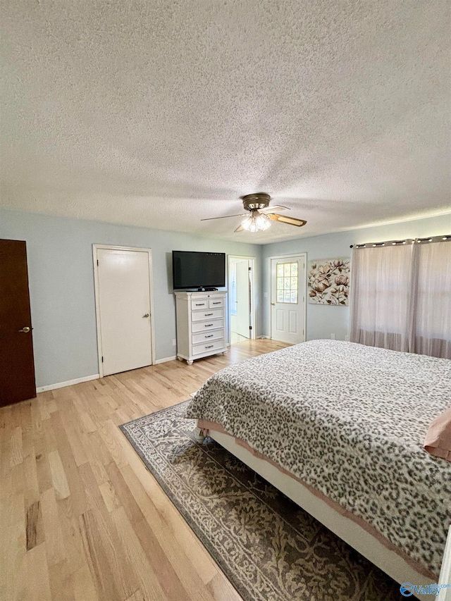 bedroom with ceiling fan, a textured ceiling, and hardwood / wood-style floors