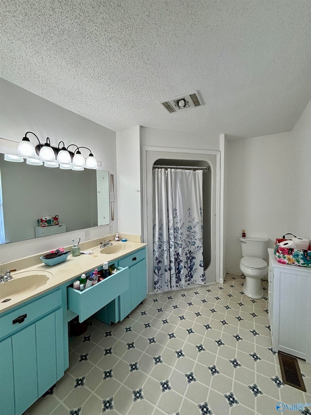 bathroom featuring vanity, toilet, and a textured ceiling