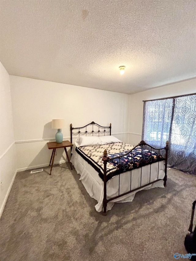 carpeted bedroom featuring a textured ceiling