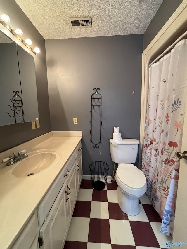 bathroom featuring vanity, toilet, and a textured ceiling