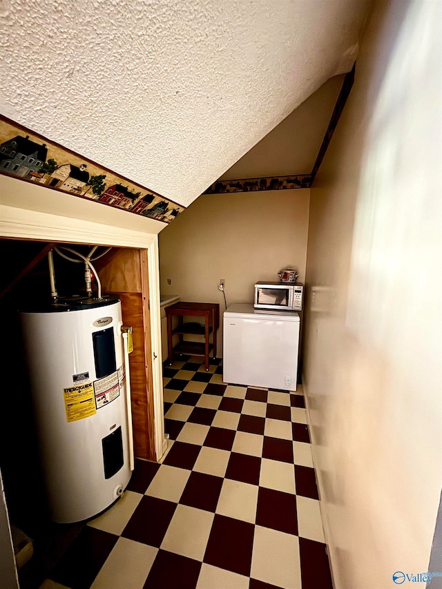 basement featuring water heater and a textured ceiling