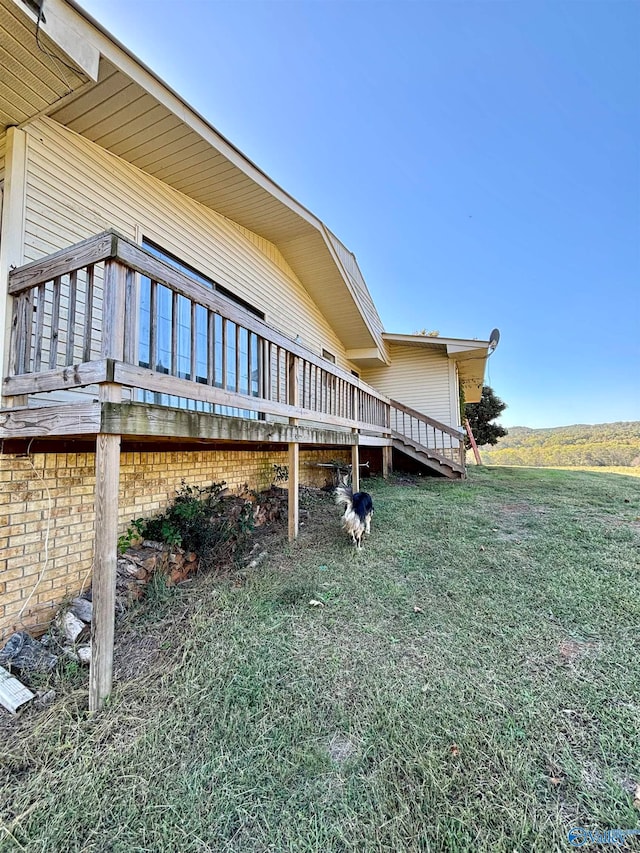 view of home's exterior with a lawn and a wooden deck