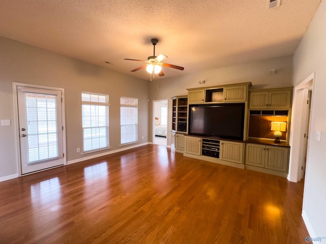 unfurnished living room with ceiling fan, wood-type flooring, and a textured ceiling