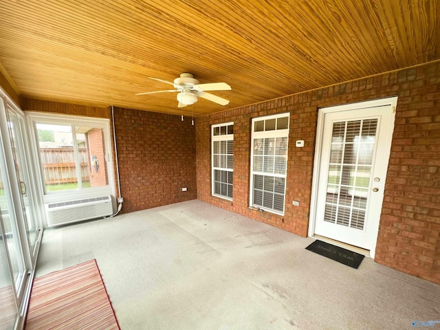 unfurnished sunroom with wood ceiling and ceiling fan