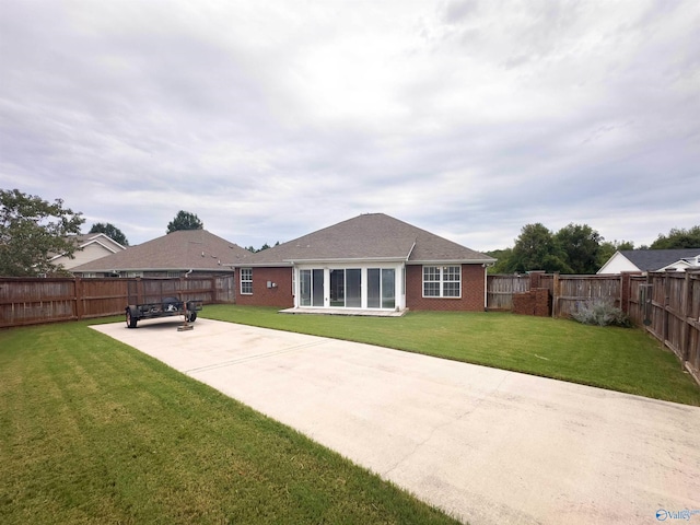 rear view of house featuring a patio and a yard