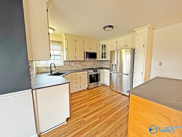 kitchen featuring light hardwood / wood-style flooring, stainless steel appliances, tasteful backsplash, and sink