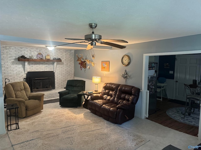 living room with ceiling fan and a fireplace