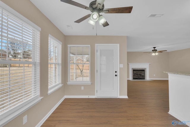 unfurnished living room featuring ceiling fan and dark hardwood / wood-style floors