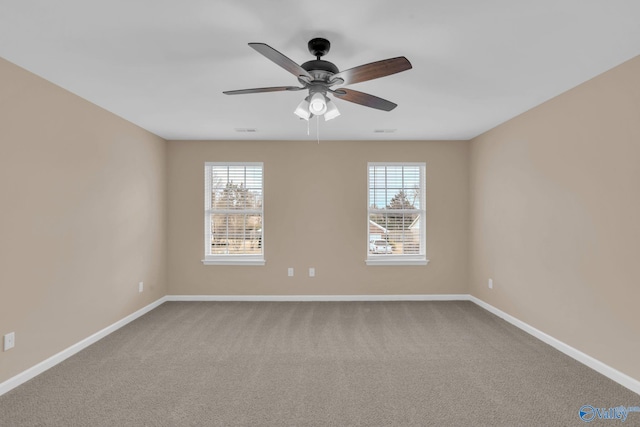 carpeted spare room featuring ceiling fan and plenty of natural light