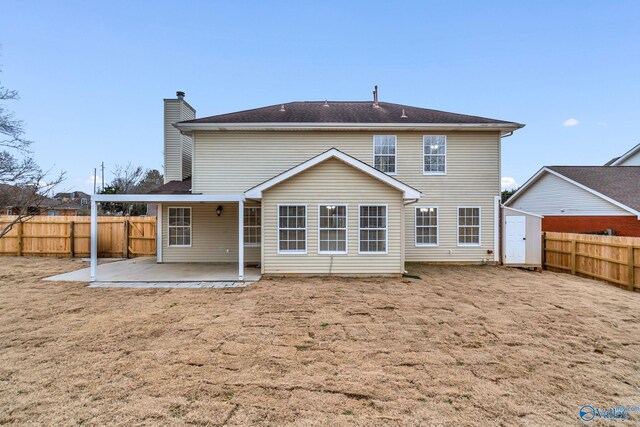 rear view of house featuring a shed, a yard, and a patio