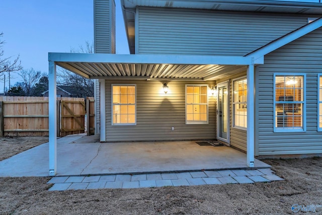 back house at dusk with a patio