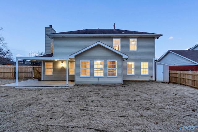 rear view of property with a patio area and a shed