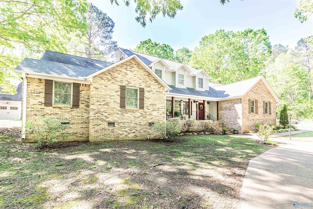 view of front of house with a shingled roof, crawl space, brick siding, and covered porch