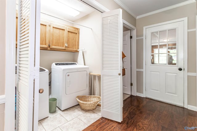 clothes washing area featuring washer / dryer, cabinet space, crown molding, and wood finished floors