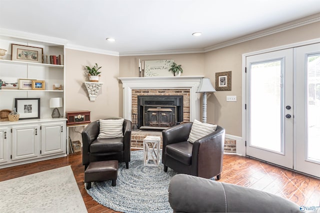 living area featuring ornamental molding, wood finished floors, french doors, a fireplace, and recessed lighting