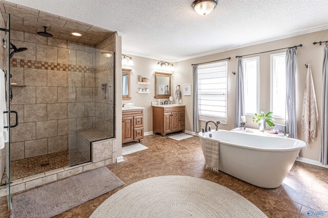 full bath with a stall shower, baseboards, a soaking tub, a textured ceiling, and vanity