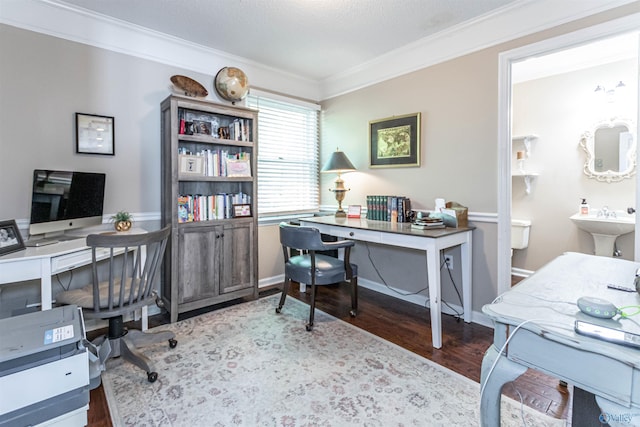 office with ornamental molding, a sink, baseboards, and wood finished floors