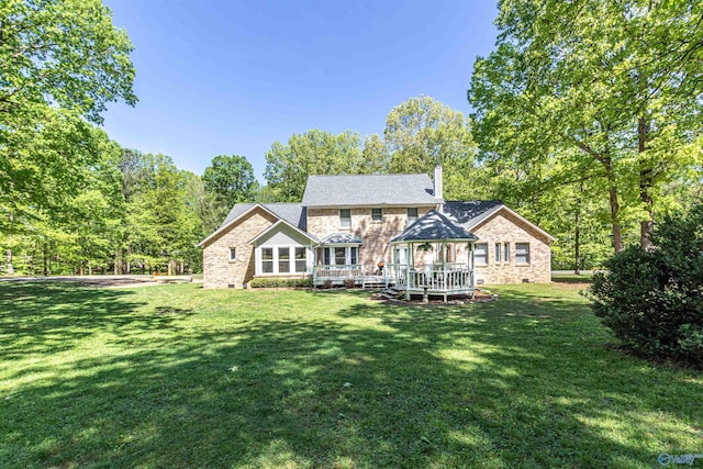 rear view of property with crawl space, a chimney, a deck, and a yard