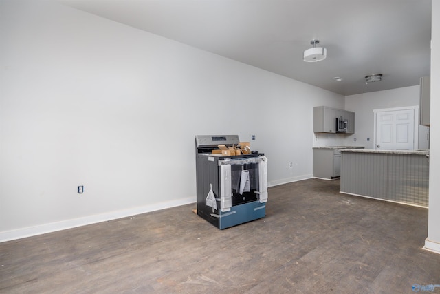 kitchen featuring gray cabinetry, stainless steel appliances, baseboards, light countertops, and dark wood finished floors