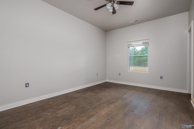 empty room featuring baseboards, visible vents, ceiling fan, and dark wood-style flooring