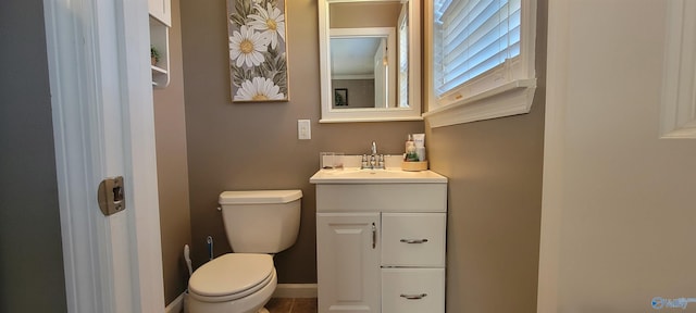 bathroom with toilet, baseboards, and vanity