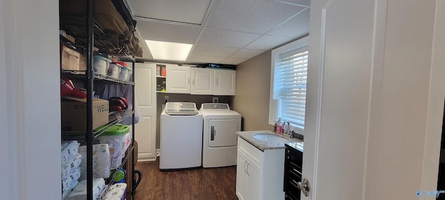 laundry area featuring washing machine and dryer, cabinet space, a sink, and dark wood finished floors