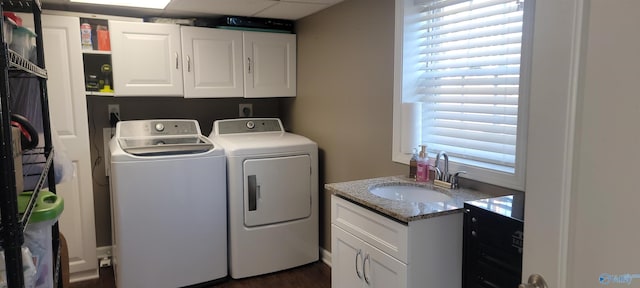 laundry room featuring cabinet space, washing machine and dryer, and a sink