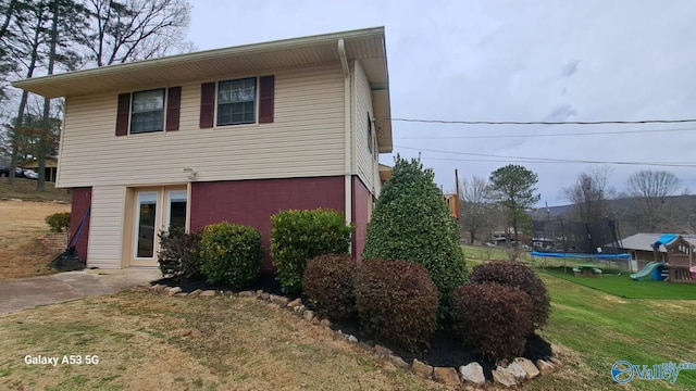 view of front of home with a front lawn, a playground, and a trampoline