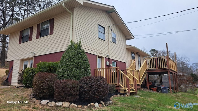 view of home's exterior with a wooden deck and a lawn
