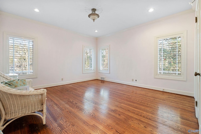 living area featuring hardwood / wood-style floors, a wealth of natural light, and ornamental molding