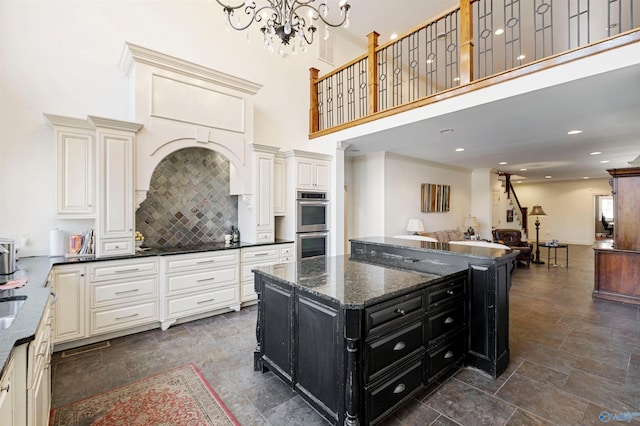 kitchen featuring tasteful backsplash, dark tile patterned floors, dark stone countertops, stainless steel double oven, and a kitchen island