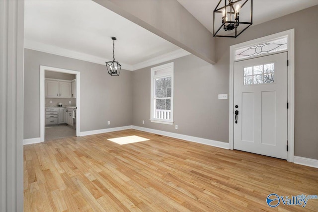 entryway featuring ornamental molding, a chandelier, and light hardwood / wood-style flooring