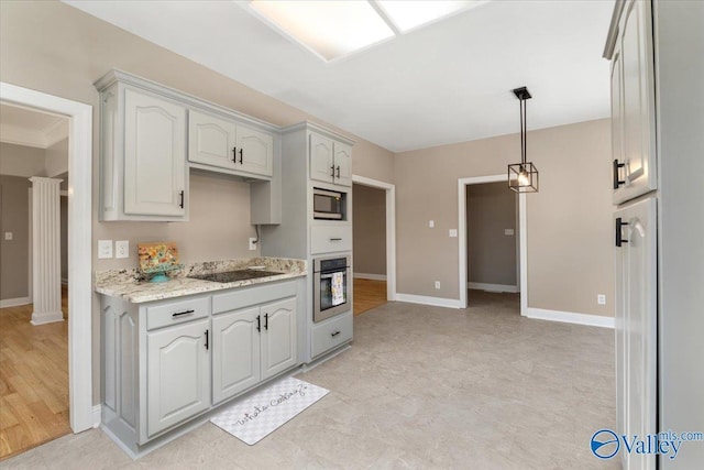 kitchen with light stone counters, pendant lighting, ornate columns, and appliances with stainless steel finishes