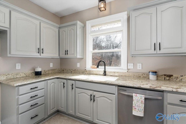 kitchen featuring stainless steel dishwasher, light stone countertops, and sink