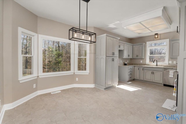 kitchen featuring pendant lighting, gray cabinets, dishwasher, and sink