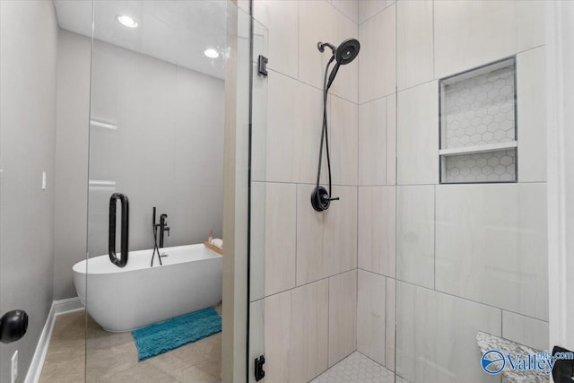 bathroom with tile patterned flooring and separate shower and tub