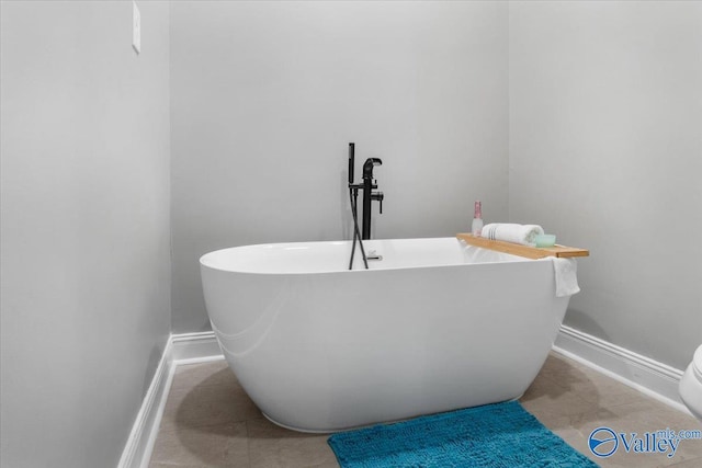 bathroom with a washtub and tile patterned floors