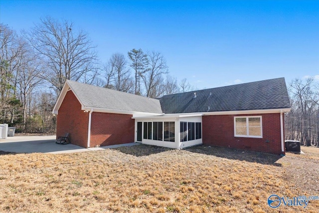 back of house featuring a yard, a patio area, and a sunroom