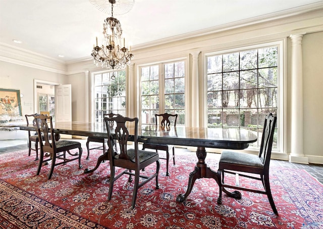 dining area featuring crown molding, decorative columns, baseboards, and a chandelier