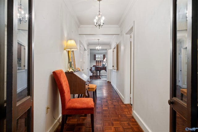 hall featuring baseboards, a notable chandelier, and ornamental molding