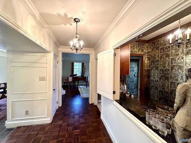 corridor featuring a chandelier, crown molding, and baseboards