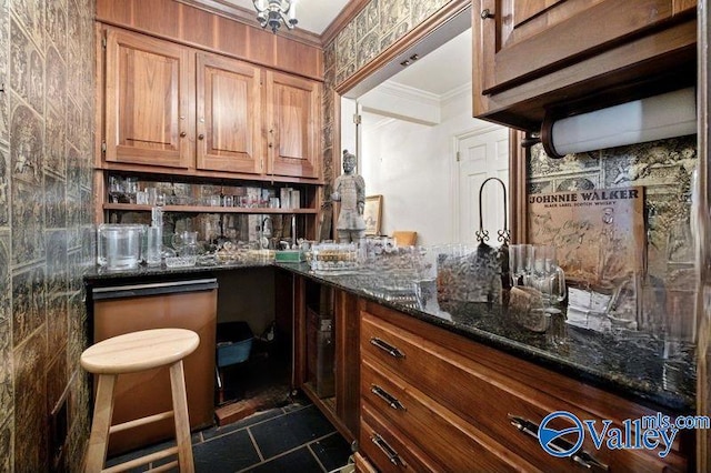 kitchen featuring dark stone counters, brown cabinetry, open shelves, and ornamental molding