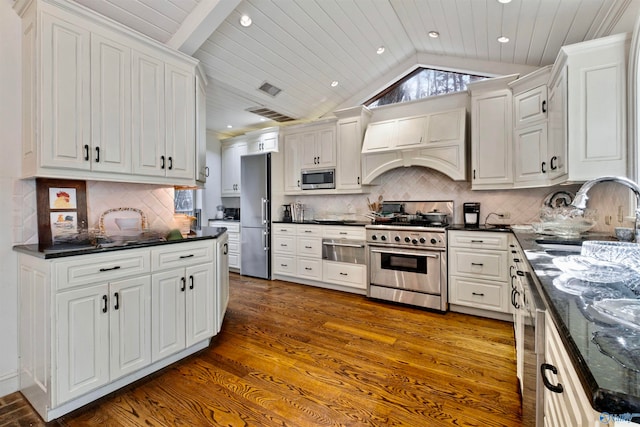 kitchen with white cabinetry, premium range hood, dark hardwood / wood-style flooring, decorative backsplash, and appliances with stainless steel finishes