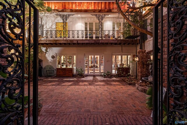 exterior space with a balcony, french doors, and a patio area