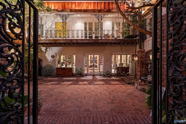 rear view of house featuring french doors, a patio, and a balcony