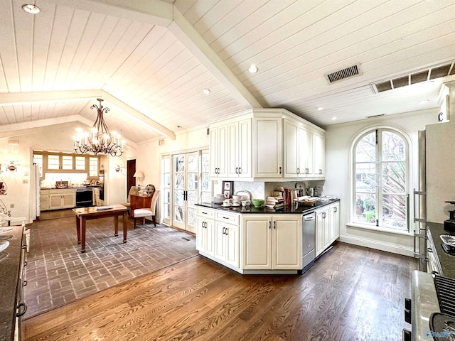 kitchen with dark countertops, visible vents, lofted ceiling with beams, and stainless steel dishwasher