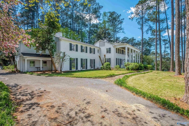 view of front of home featuring a front lawn, driveway, and stucco siding