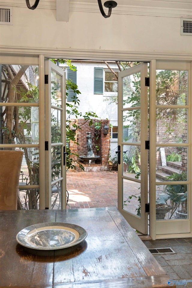 entryway featuring visible vents, plenty of natural light, and ornamental molding