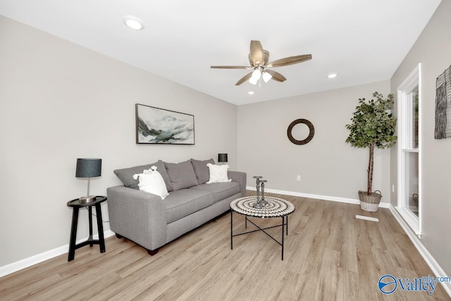 living room with ceiling fan and light hardwood / wood-style flooring